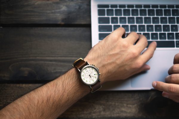 vue sur un poignée portant une montre, posé sur un clavier d'ordinateur portable