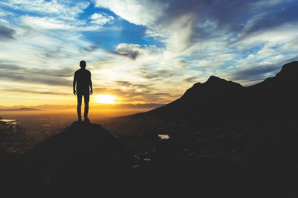 Homme le haut d'une colline qui contemple l'horizon